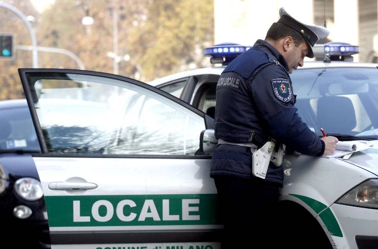 un vigile compila un verbale di multa