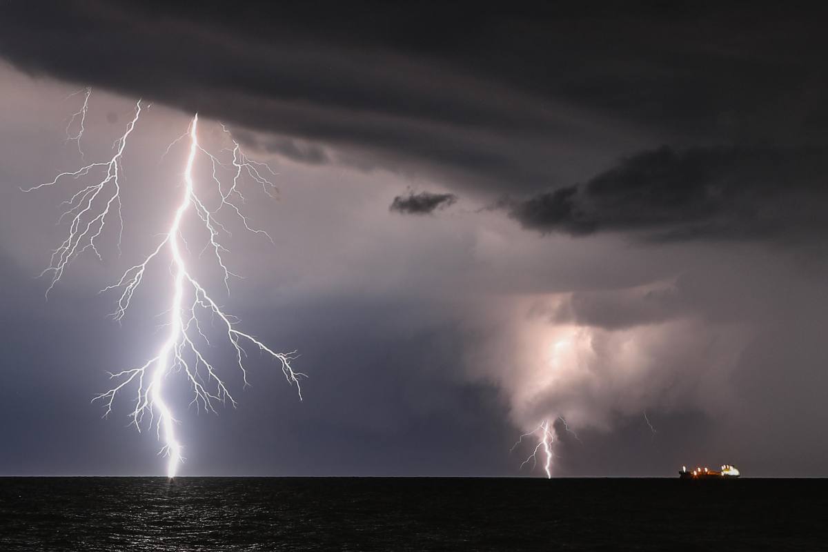 Cielo nuvoloso e fulmini che cadono a mare