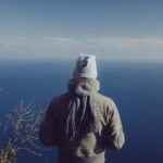 Uomo con abiti invernali al mare