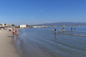Persone in spiaggia che passeggiano o fanno il bagno