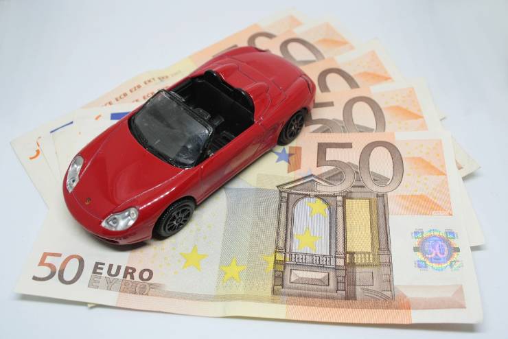 banconote da 50 euro con sopra il modellino di un'auto