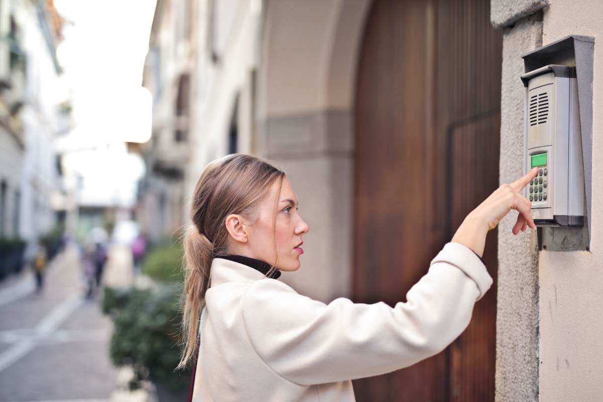 Persona che suona al citofono di un palazzo