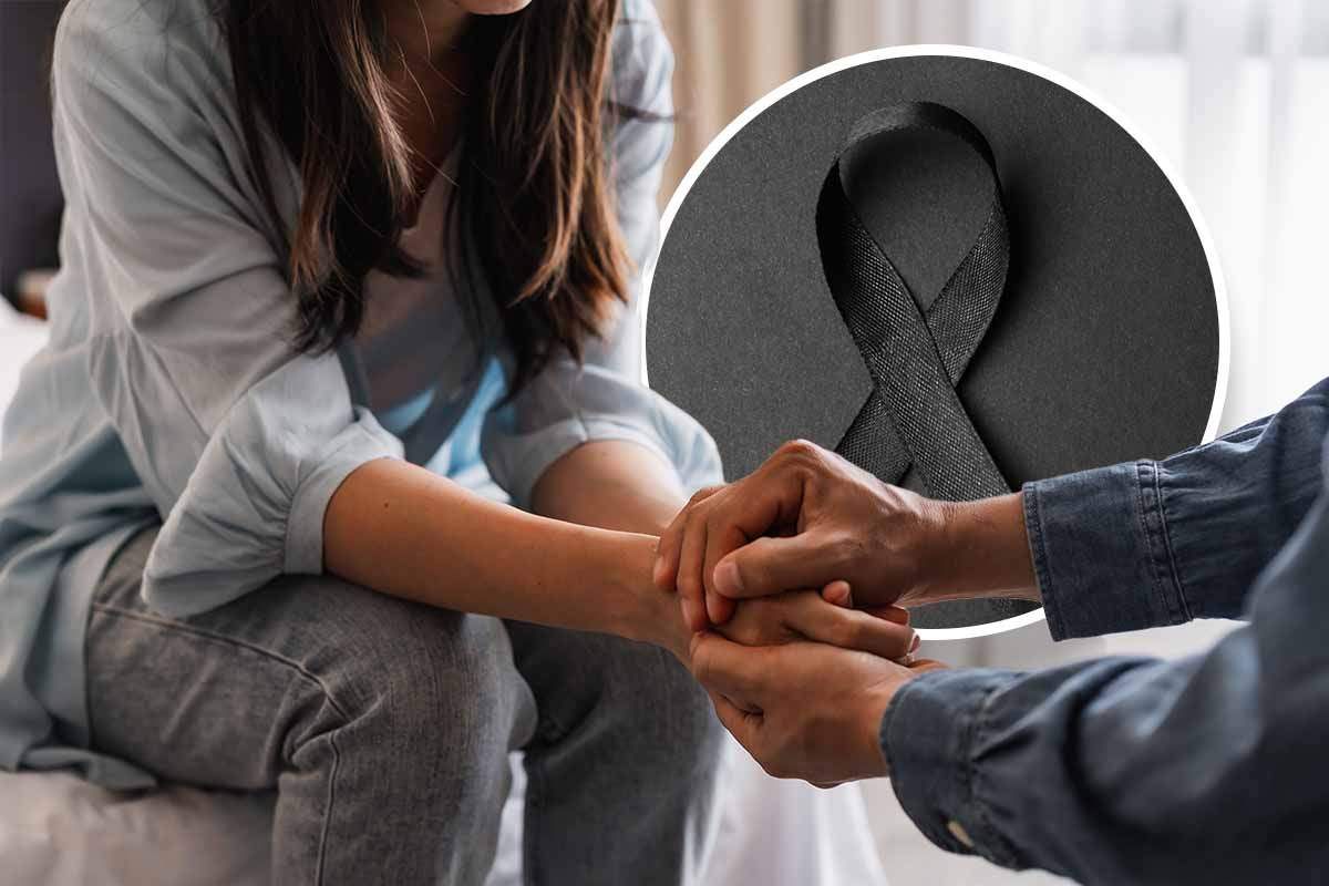 Nastro nero a lutto e persone che si tengono la mano