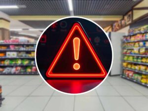 segnale di pericolo con dietro scaffali di un supermercato