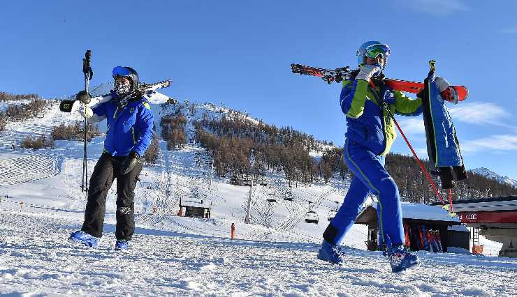 due sciatori con gli sci in spalla
