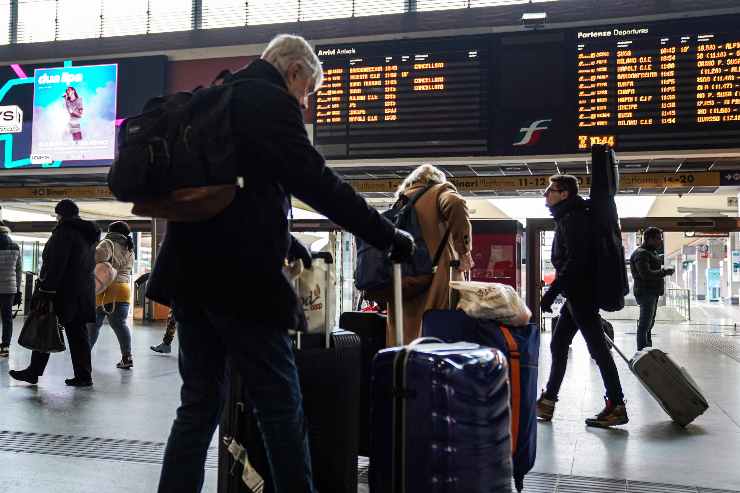 persone con i bagagli in stazione
